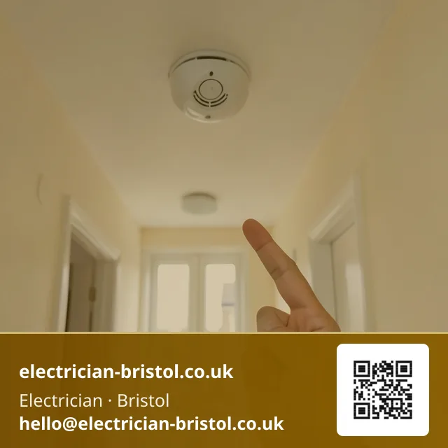 Ceiling-mounted smoke alarm being tested in a rental hallway